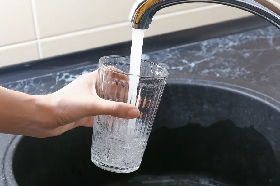A glass of water being filled from the tap