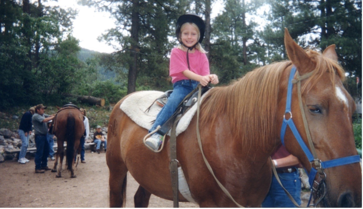 Annie as a child rides a horse